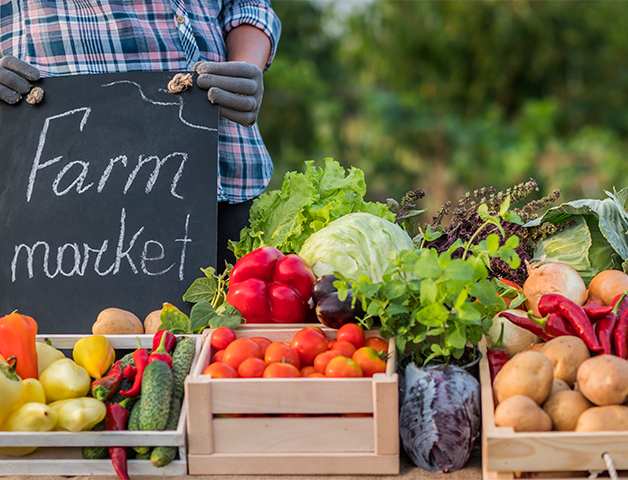 Chalkboard that says "Farm market" behind fresh produce